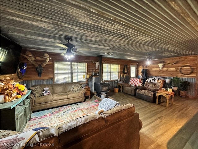 29477 360th Ave, Mccurtain, OK 74944 - living room featuring a wood stove, a ceiling fan, wooden walls, and wood finished floors