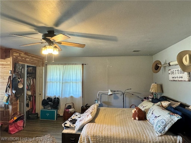 bedroom with ceiling fan, a closet, dark wood-type flooring, and a textured ceiling