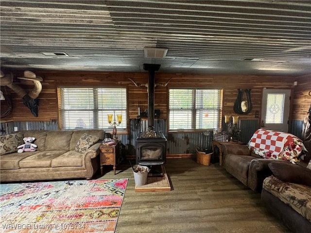 living room with a wood stove and wood-type flooring