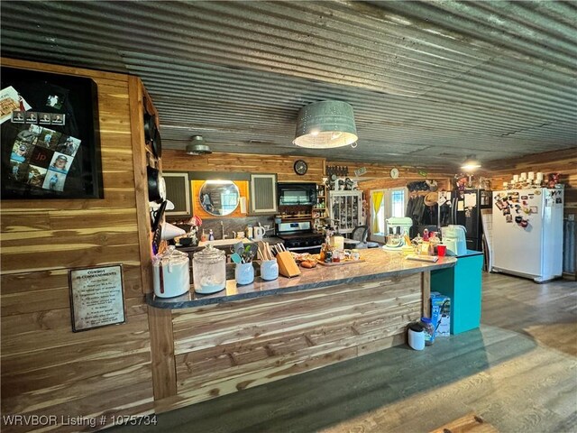 29477 360th Ave, Mccurtain, OK 74944 - bar area featuring freestanding refrigerator, wood finished floors, wooden walls, black microwave, and stainless steel stove