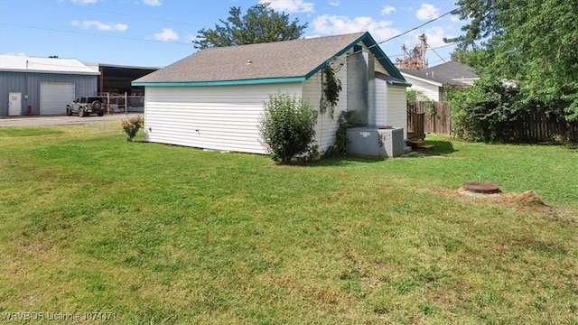 view of side of property featuring a lawn and an outbuilding