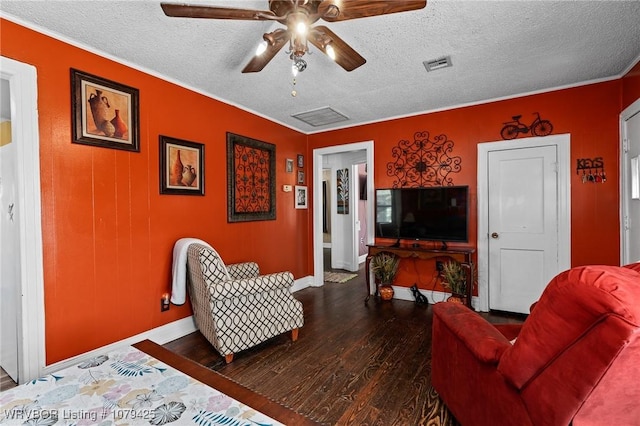 living room featuring visible vents, a textured ceiling, wood finished floors, baseboards, and ceiling fan