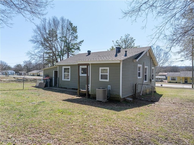 back of house featuring a yard, central AC, and fence