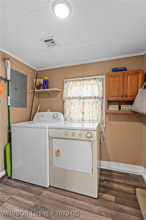 clothes washing area featuring wood finished floors, electric panel, separate washer and dryer, and visible vents