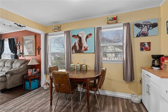 dining area featuring baseboards, wood finished floors, and ornamental molding