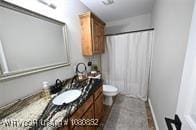 bathroom with toilet, vanity, and a shower with shower curtain