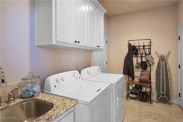 laundry area featuring light tile patterned flooring, cabinets, sink, and washing machine and clothes dryer