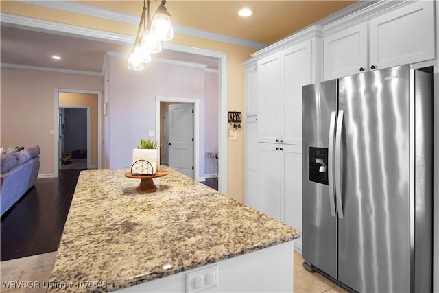 kitchen featuring light stone countertops, ornamental molding, decorative light fixtures, stainless steel fridge with ice dispenser, and white cabinetry