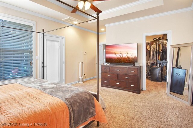 bedroom featuring light colored carpet, a spacious closet, ceiling fan, and ornamental molding