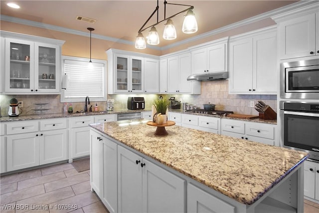 kitchen featuring hanging light fixtures, white cabinetry, sink, and stainless steel appliances