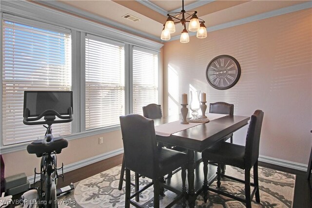 dining room featuring a notable chandelier, wood-type flooring, and ornamental molding