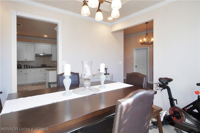 dining area featuring a chandelier and crown molding