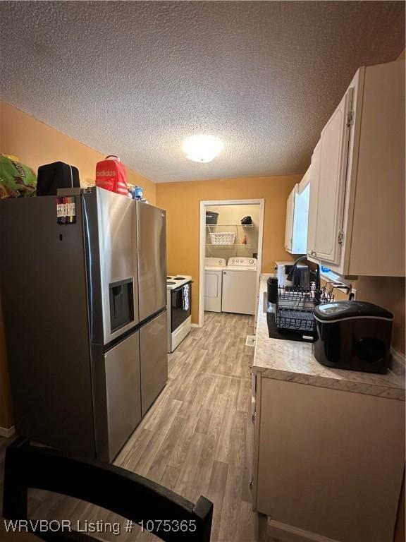 kitchen featuring white range with electric cooktop, white cabinetry, washing machine and dryer, light hardwood / wood-style floors, and stainless steel fridge with ice dispenser