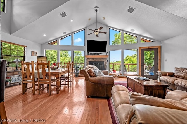 95147 S 4507th Rd, Vian, OK 74962 - living area featuring ceiling fan, a glass covered fireplace, plenty of natural light, light wood-style floors, and high vaulted ceiling