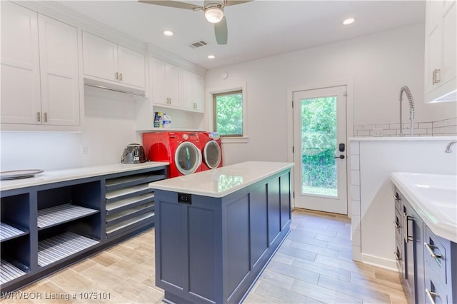 4001 Spring Mountain Rd, Fort Smith, AR 72916 - kitchen with white cabinets, ceiling fan, a kitchen island, and washing machine and dryer