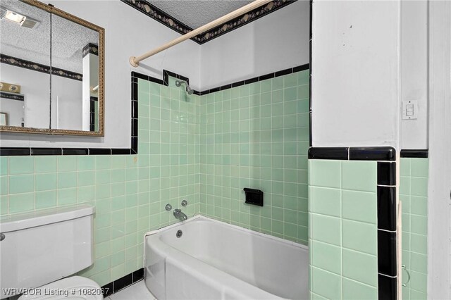 19 Hiland Dr, Fort Smith, AR 72901 - bathroom featuring tile walls, shower / washtub combination, and a textured ceiling