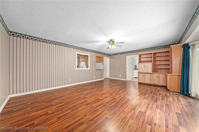 19 Hiland Dr, Fort Smith, AR 72901 - unfurnished living room featuring a textured ceiling, ceiling fan, wood finished floors, and wallpapered walls