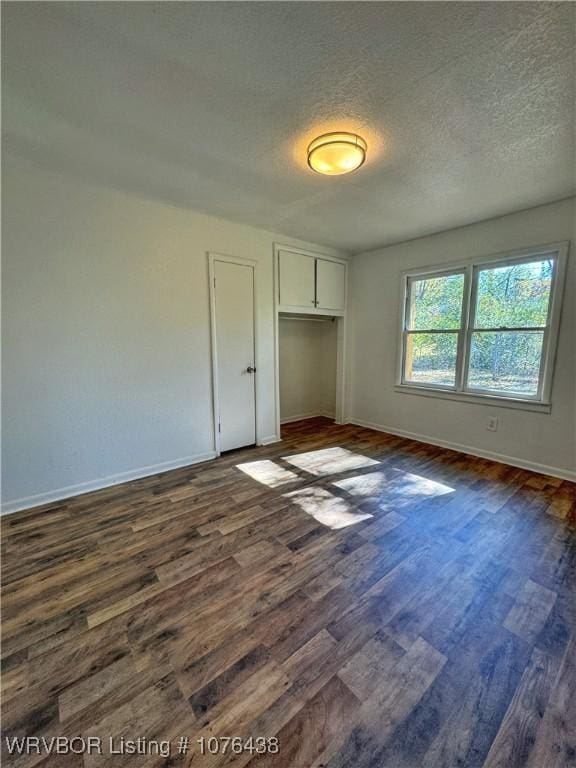 unfurnished bedroom featuring dark hardwood / wood-style flooring, a closet, and a textured ceiling