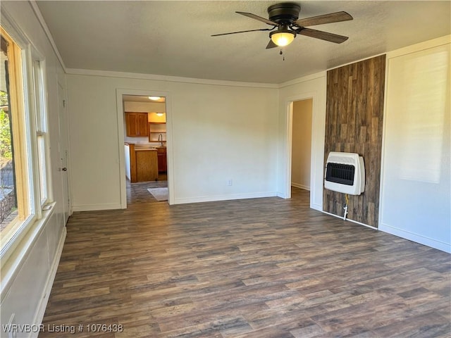 unfurnished living room with dark wood-type flooring, sink, heating unit, ornamental molding, and ceiling fan