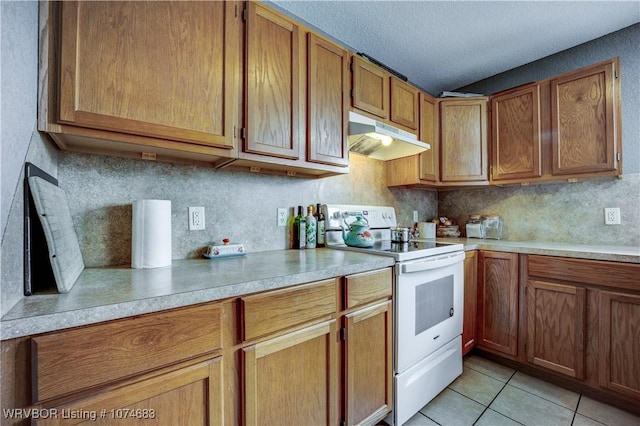 kitchen with white electric range, a textured ceiling, light tile patterned floors, and tasteful backsplash