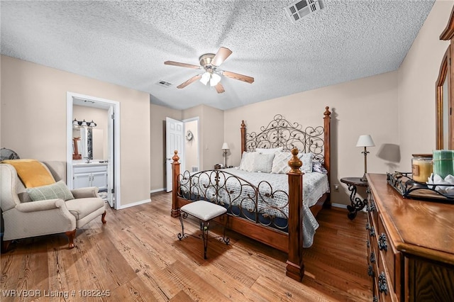 309 Neal Dr, Roland, OK 74954 - bedroom featuring wood finished floors, a textured ceiling, ensuite bathroom, and ceiling fan