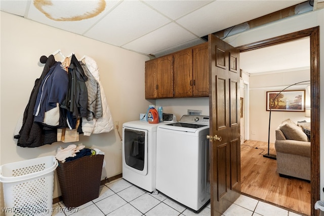 laundry area with cabinets, light tile patterned floors, and washing machine and dryer