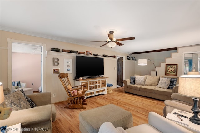 living room with hardwood / wood-style floors, ceiling fan, and ornamental molding