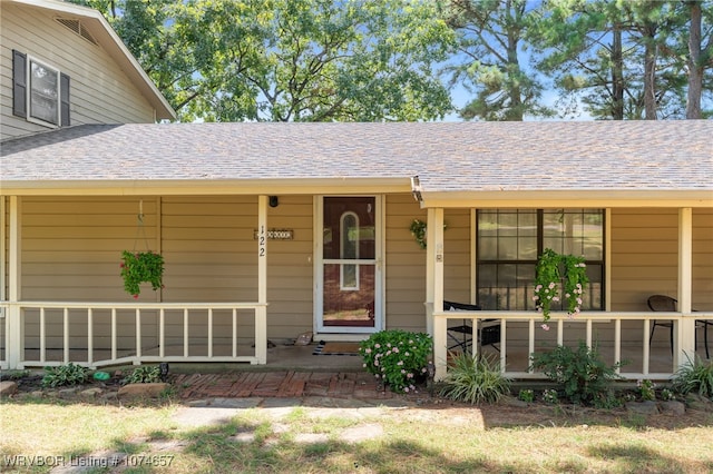 view of exterior entry featuring covered porch