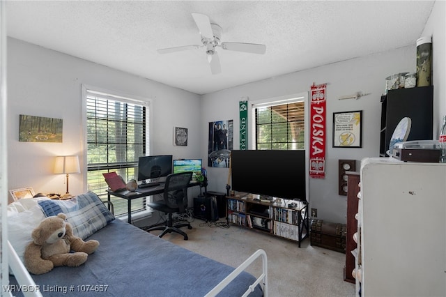 office area with light carpet, a textured ceiling, and ceiling fan