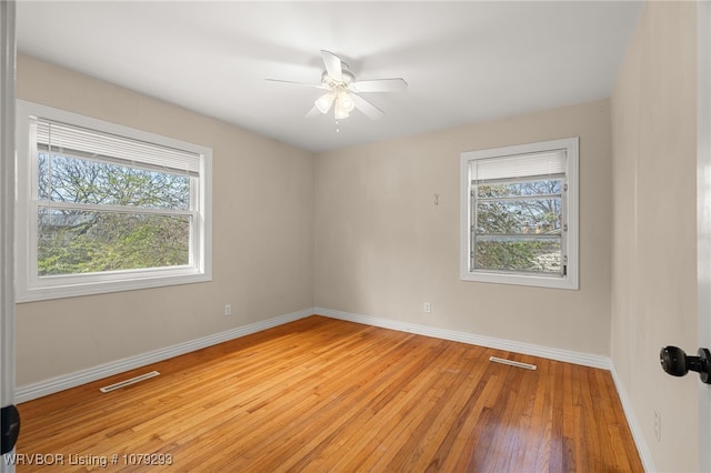 unfurnished room with baseboards, light wood-style flooring, and a healthy amount of sunlight