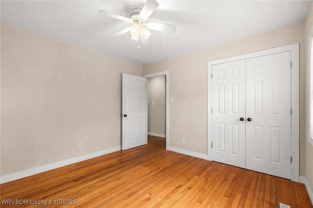 unfurnished bedroom featuring ceiling fan, a closet, light wood-type flooring, and baseboards