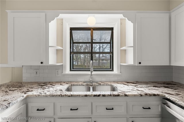 kitchen featuring open shelves, backsplash, white cabinets, a sink, and dishwasher