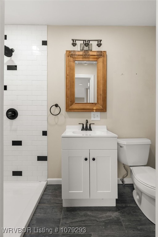 full bath with toilet, baseboards, a shower, and vanity