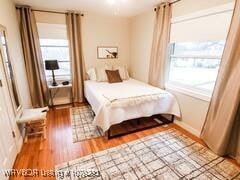 bedroom featuring multiple windows and wood finished floors