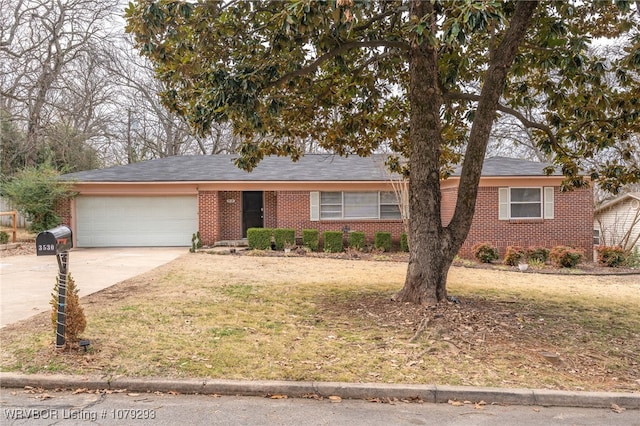 single story home featuring a front yard, brick siding, driveway, and an attached garage