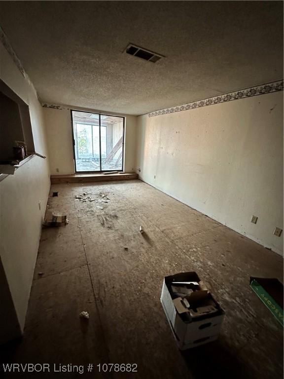 unfurnished room with a textured ceiling