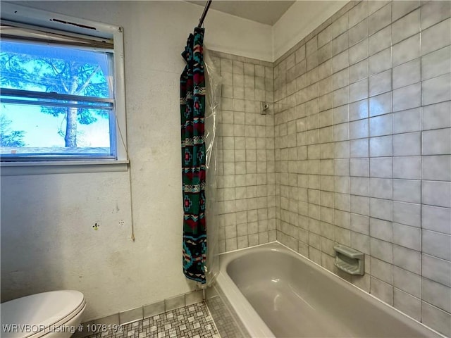 bathroom featuring tile patterned floors, shower / bath combo, and toilet