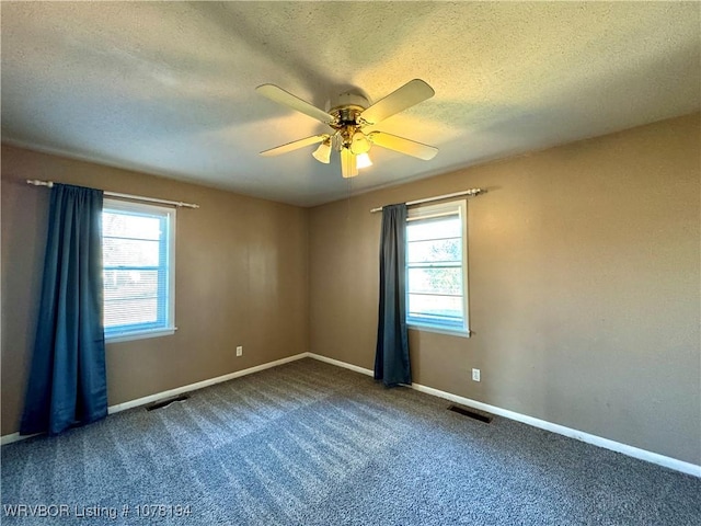 spare room featuring carpet flooring, ceiling fan, and a textured ceiling