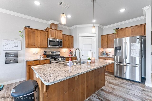 1228 Bradley St, Centerton, AR 72719 - kitchen featuring stainless steel appliances, light wood finished floors, brown cabinetry, light stone countertops, and ornamental molding