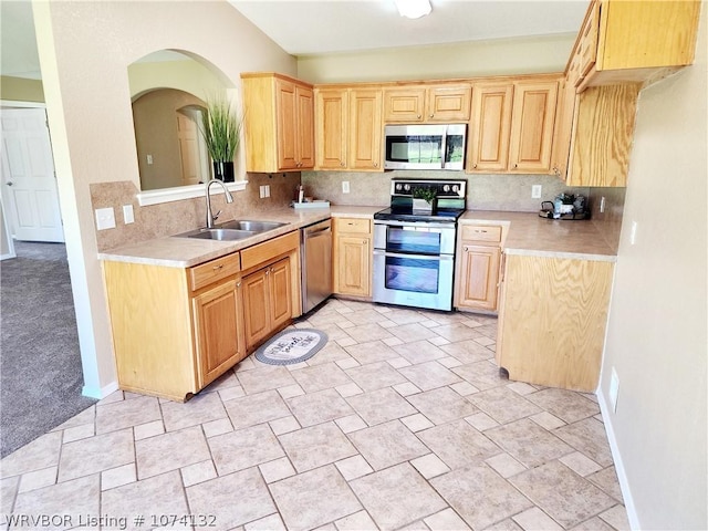 kitchen featuring light brown cabinetry, decorative backsplash, sink, and stainless steel appliances