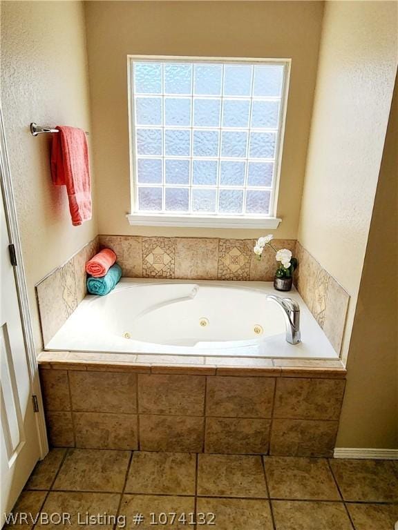 bathroom featuring tile patterned flooring and tiled bath