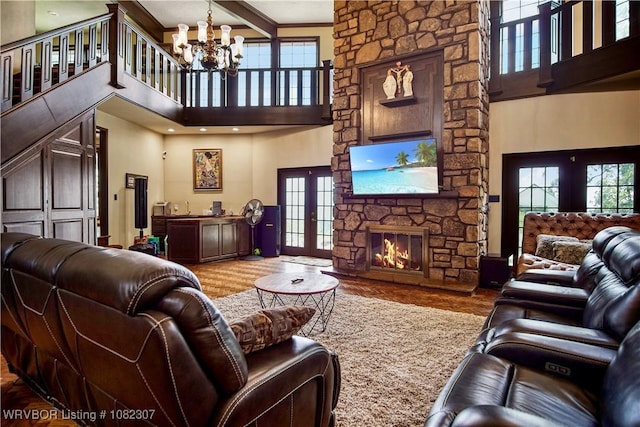 3417 Royal Scots Way, Fort Smith, AR 72908 - living area featuring a towering ceiling, a chandelier, french doors, wood finished floors, and a stone fireplace