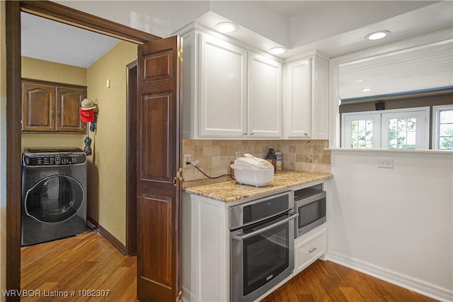 3417 Royal Scots Way, Fort Smith, AR 72908 - kitchen featuring washer / dryer, stainless steel appliances, dark wood finished floors, white cabinets, and decorative backsplash
