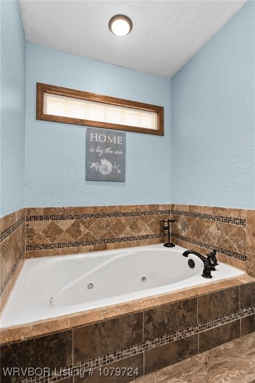 2702 Rambo Cir, Lavaca, AR 72941 - full bath featuring a tub with jets and a textured wall