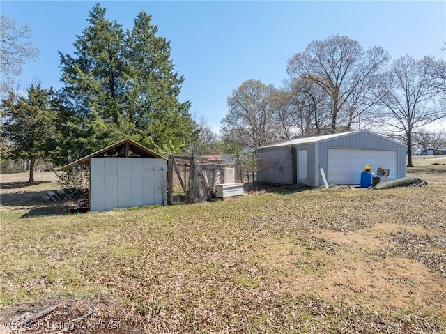 view of yard featuring a detached garage and an outbuilding
