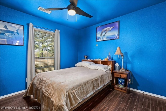 bedroom with visible vents, baseboards, wood finish floors, and a ceiling fan