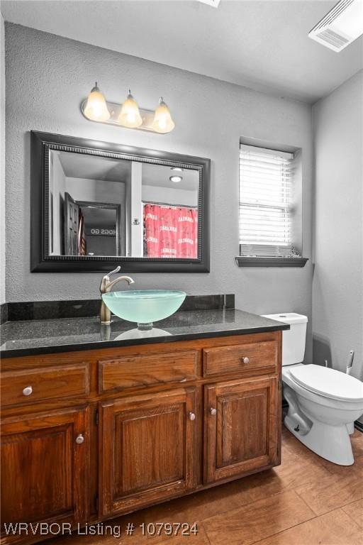 full bath featuring visible vents, toilet, and vanity