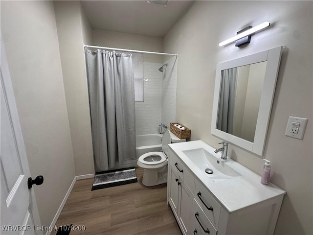 bathroom with toilet, wood finished floors, vanity, and baseboards