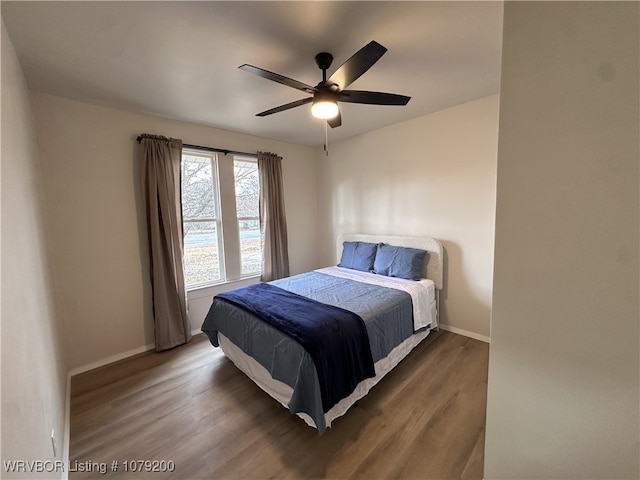 bedroom featuring dark wood-type flooring, ceiling fan, and baseboards