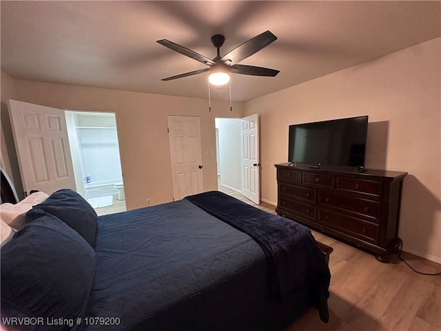 bedroom featuring baseboards, ceiling fan, ensuite bath, and light wood finished floors